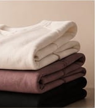 Camisetas dobradas em bege, vinho e preto